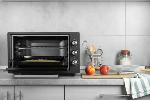 Fornetto elettrico aperto sul piano della cucina