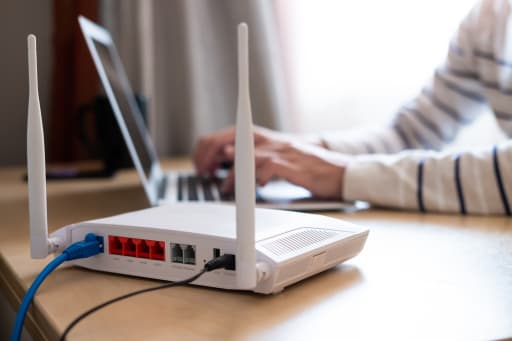 persona che lavora al pc con router in primo piano persona che lavora al pc con router in primo piano