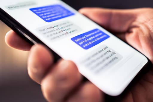 mano che tiene smartphone con sms sullo schermo mano che tiene smartphone con sms sullo schermo