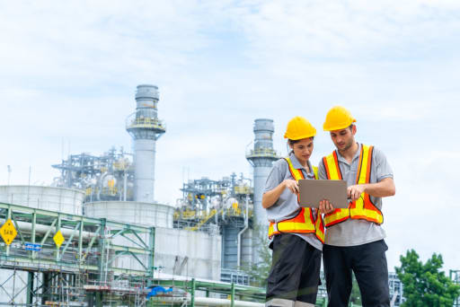 operai guardano dati su un tablet in un impianto industriale operai guardano dati su un tablet in un impianto industriale