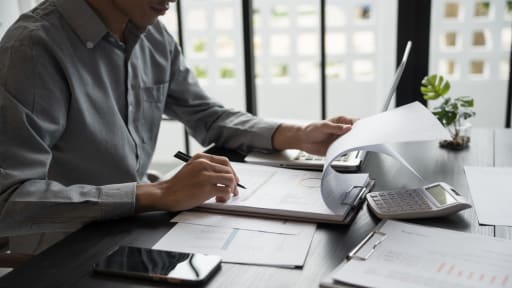 uomo controlla fogli su scrivania uomo controlla fogli su scrivania