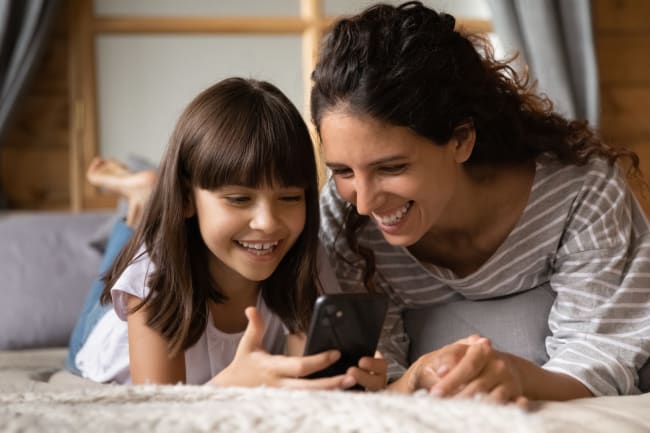 mamma e figlia guardano lo smartphone mamma e figlia guardano lo smartphone