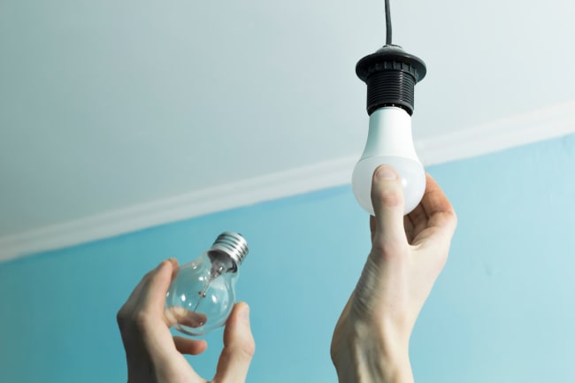 Persona che sta cambiando una lampadina Persona che sta cambiando una lampadina