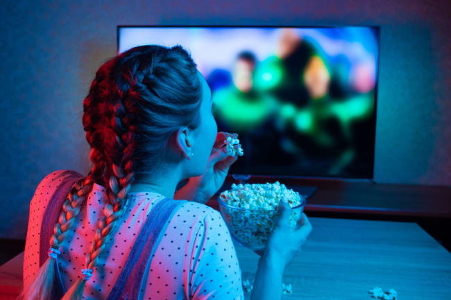 ragazza che guarda la smart tv con popcorn ragazza che guarda la smart tv con popcorn