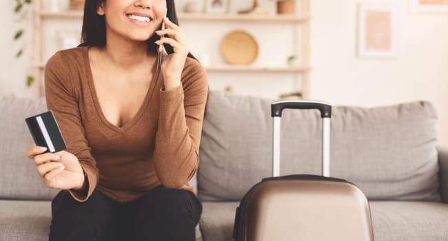 donna con carta di credito in mano e valigia