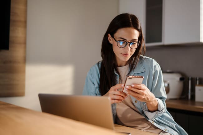 Ragazza naviga con pc e smartphone Ragazza naviga con pc e smartphone