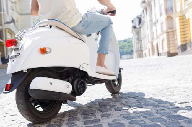 primo piano di uomo che guida uno scooter