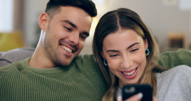 Coppia di ragazzi guarda offerte su smartphone Coppia di ragazzi guarda offerte su smartphone