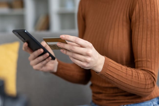 Donna che controlla transazioni con carta di credito in mano Donna che controlla transazioni con carta di credito in mano