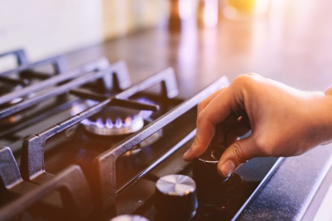 Mano che accende il fornello del gas Mano che accende il fornello del gas
