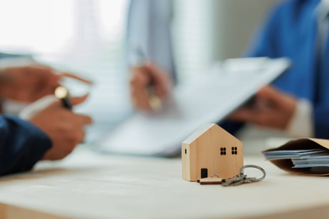modellino di casa in legno su tavolo di ufficio finanziario