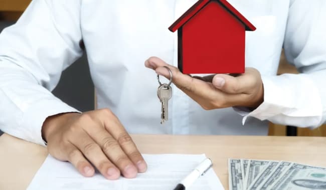 persona con modellino di casa e chiavi