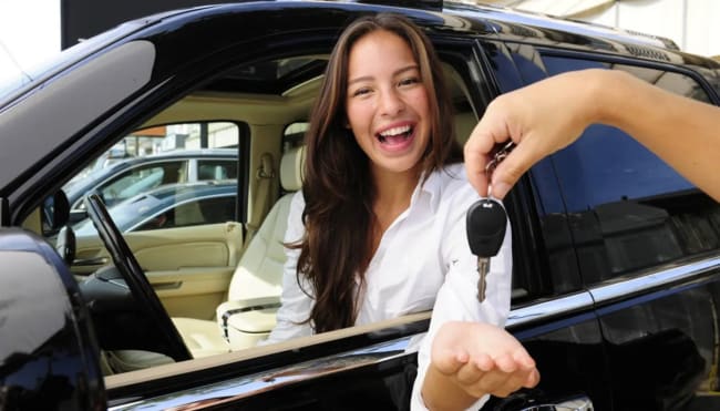ragazza sorridente riceve le chiavi dell'auto a noleggio ragazza sorridente riceve le chiavi dell'auto a noleggio