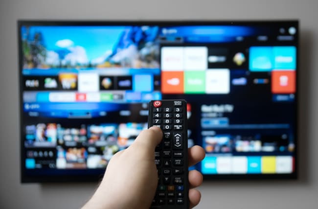Persona che naviga tra le app della smart tv con il telecomando Persona che naviga tra le app della smart tv con il telecomando