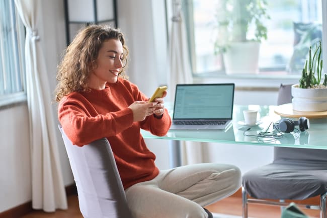 Ragazza al pc con smartphone