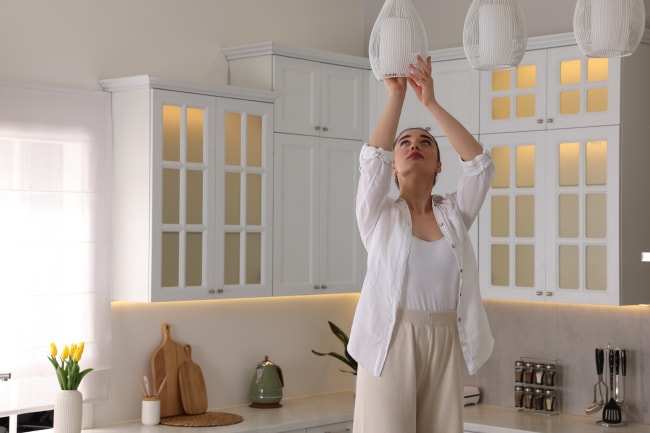 Ragazza cambia lampadine in cucina Ragazza cambia lampadine in cucina