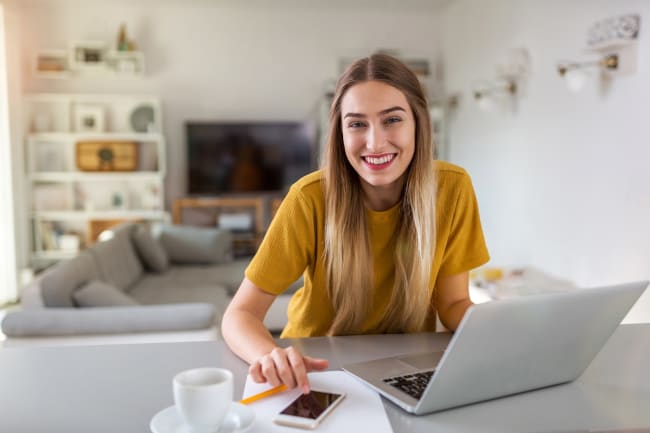 Ragazza felice con computer alla scrivania Ragazza felice con computer alla scrivania
