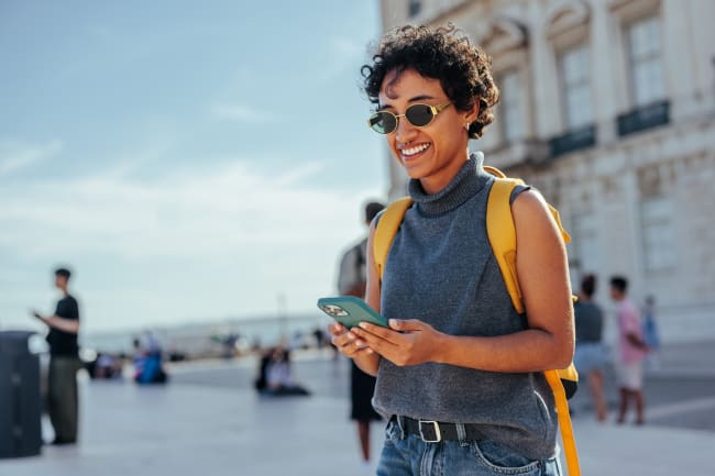 Ragazza usa smartphone in vacanza