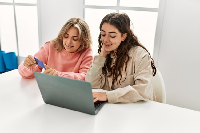 Ragazze giovani che usano carta di credito Ragazze giovani che usano carta di credito