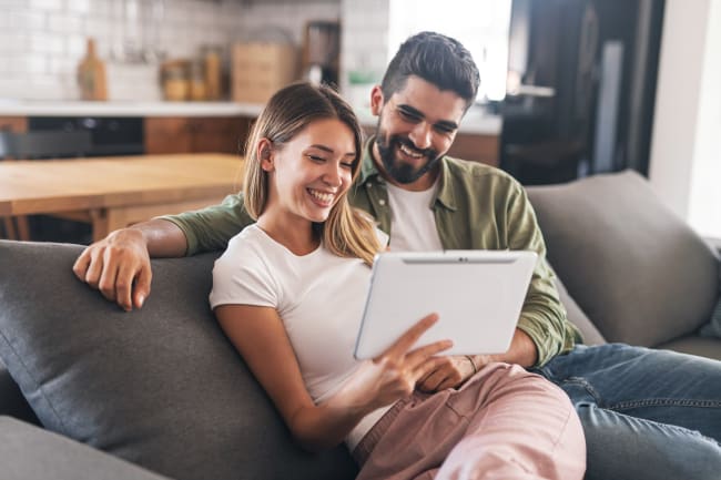 Ragazzi sorridenti su divano con tablet Ragazzi sorridenti su divano con tablet