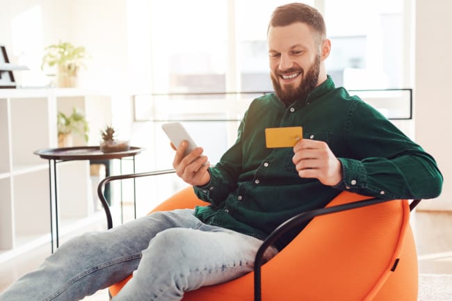 Ragazzo al cellulare con carta di credito