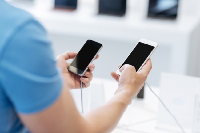 ragazzo che confronta smartphone ragazzo che confronta smartphone