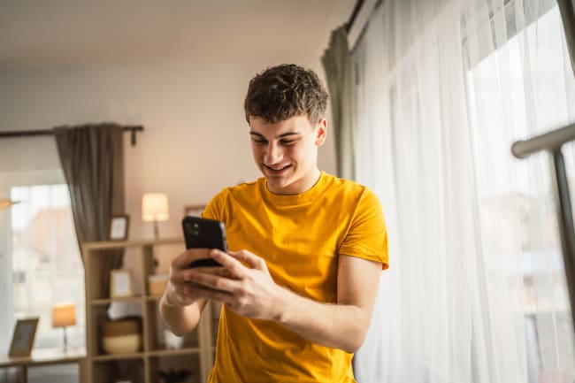Ragazzo che utilizza il suo smartphone Ragazzo che utilizza il suo smartphone