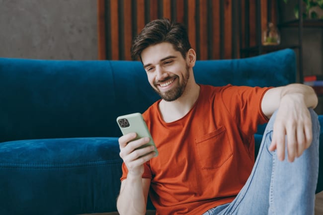 Ragazzo sorridente al cellulare Ragazzo sorridente al cellulare