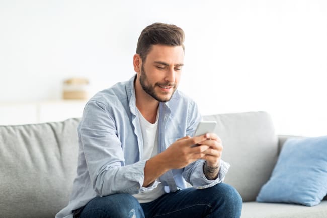 ragazzo su divano con smartphone ragazzo su divano con smartphone