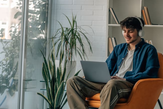 Ragazzo su poltrona che naviga in internet Ragazzo su poltrona che naviga in internet