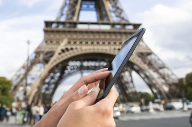 persona usa lo smartphone sotto la torre eiffel persona usa lo smartphone sotto la torre eiffel