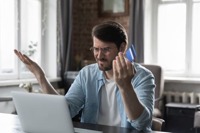 Uomo a pc preoccupato che controlla conto Uomo a pc preoccupato che controlla conto