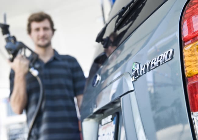 uomo che fa rifornimento auto ibrida uomo che fa rifornimento auto ibrida