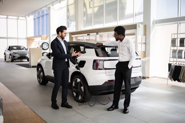 Uomo che sceglie suv elettrico in concessionaria Uomo che sceglie suv elettrico in concessionaria