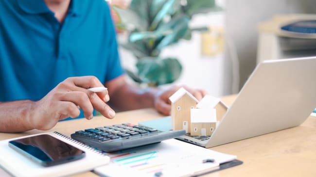 uomo con calcolatrice e computer