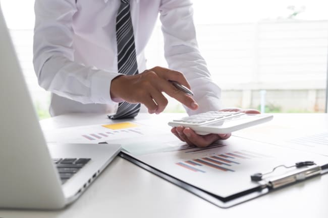 uomo d affari che usa la calcolatrice sul tavolo in ufficio uomo d affari che usa la calcolatrice sul tavolo in ufficio