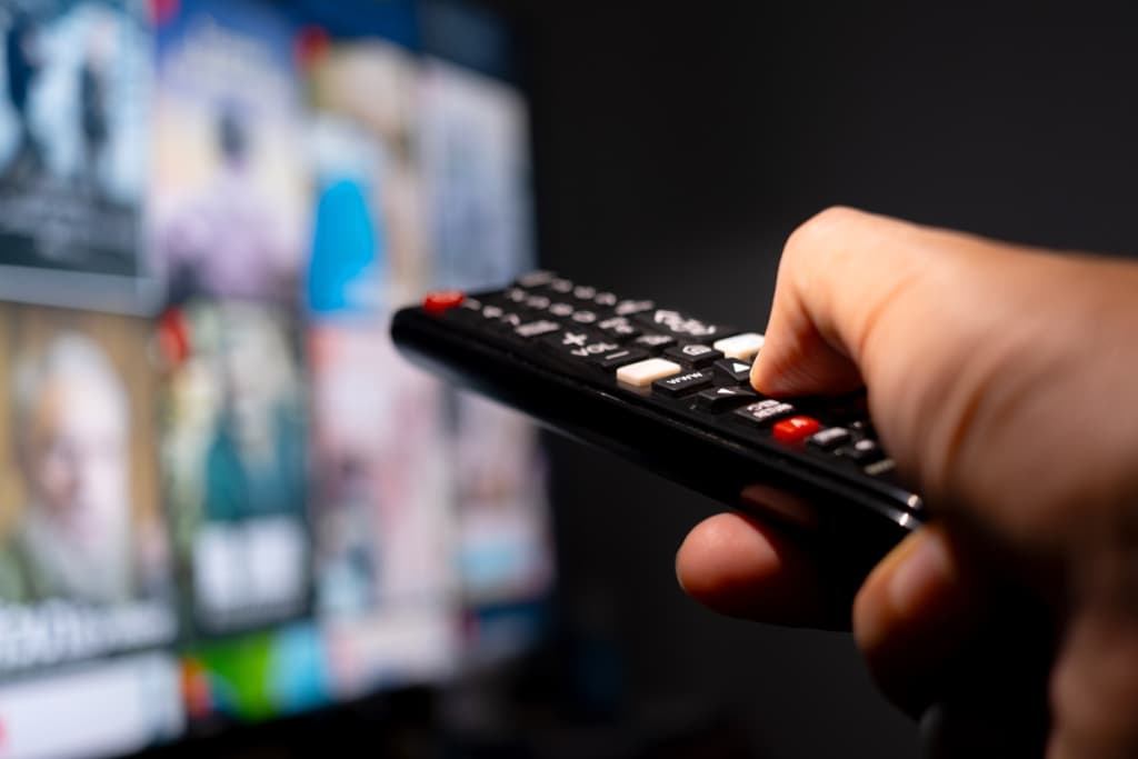 persona che tiene in mano un telecomando