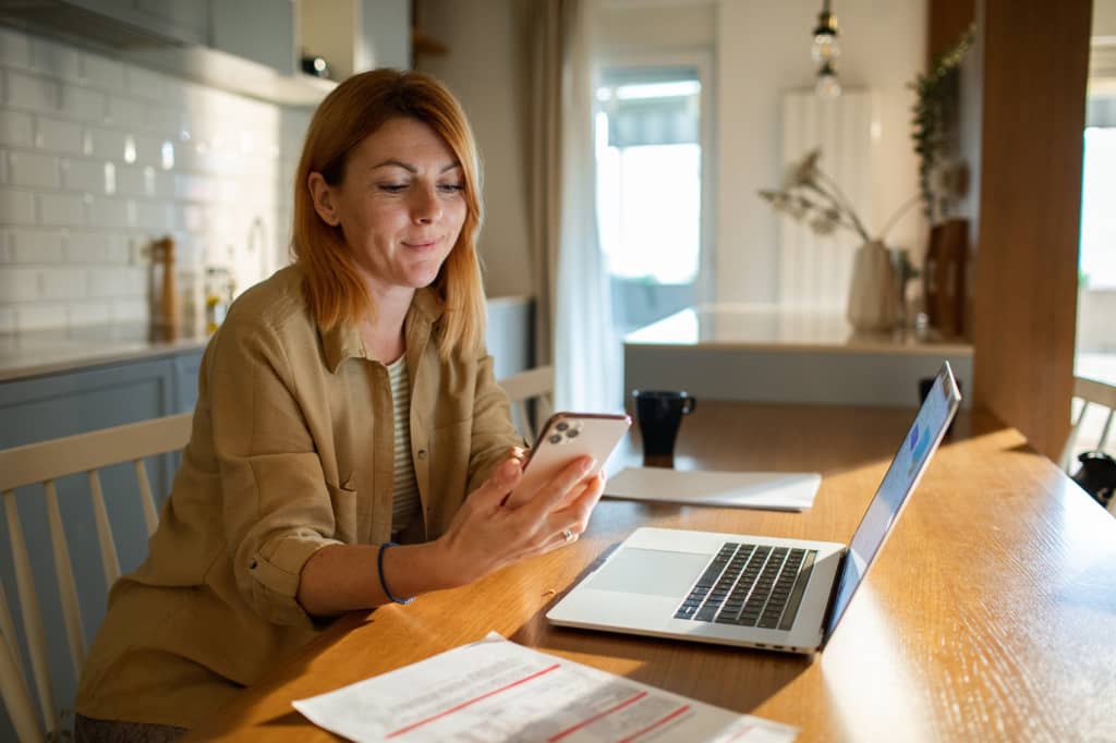 Donna che utilizza pc e smartphone Donna che utilizza pc e smartphone