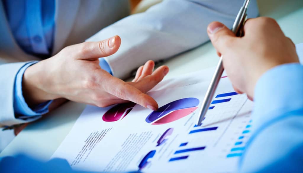 mani che indicano fogli con grafici finanziari mani che indicano fogli con grafici finanziari