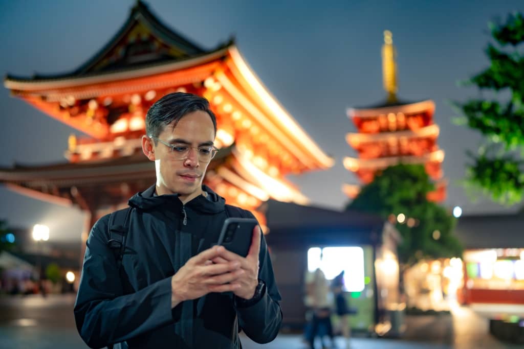 turista occidentale con smartphone in Giappone turista occidentale con smartphone in Giappone