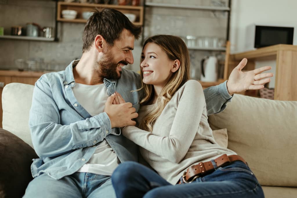 coppia che si abbraccia felice sul divano di casa