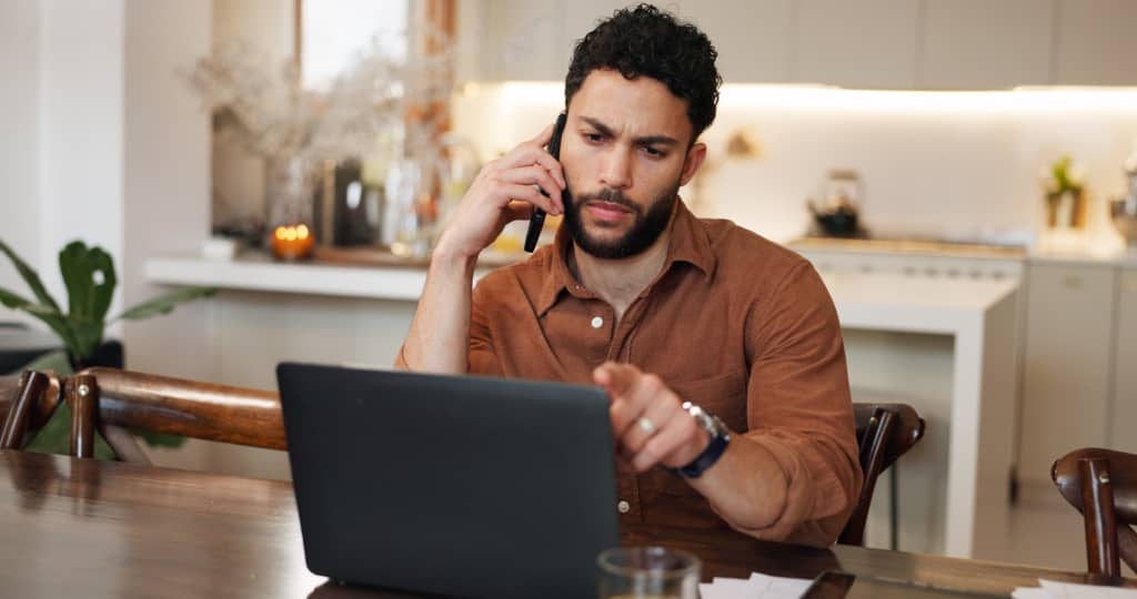 ragazzo parla al telefono mentre controlla pc ragazzo parla al telefono mentre controlla pc