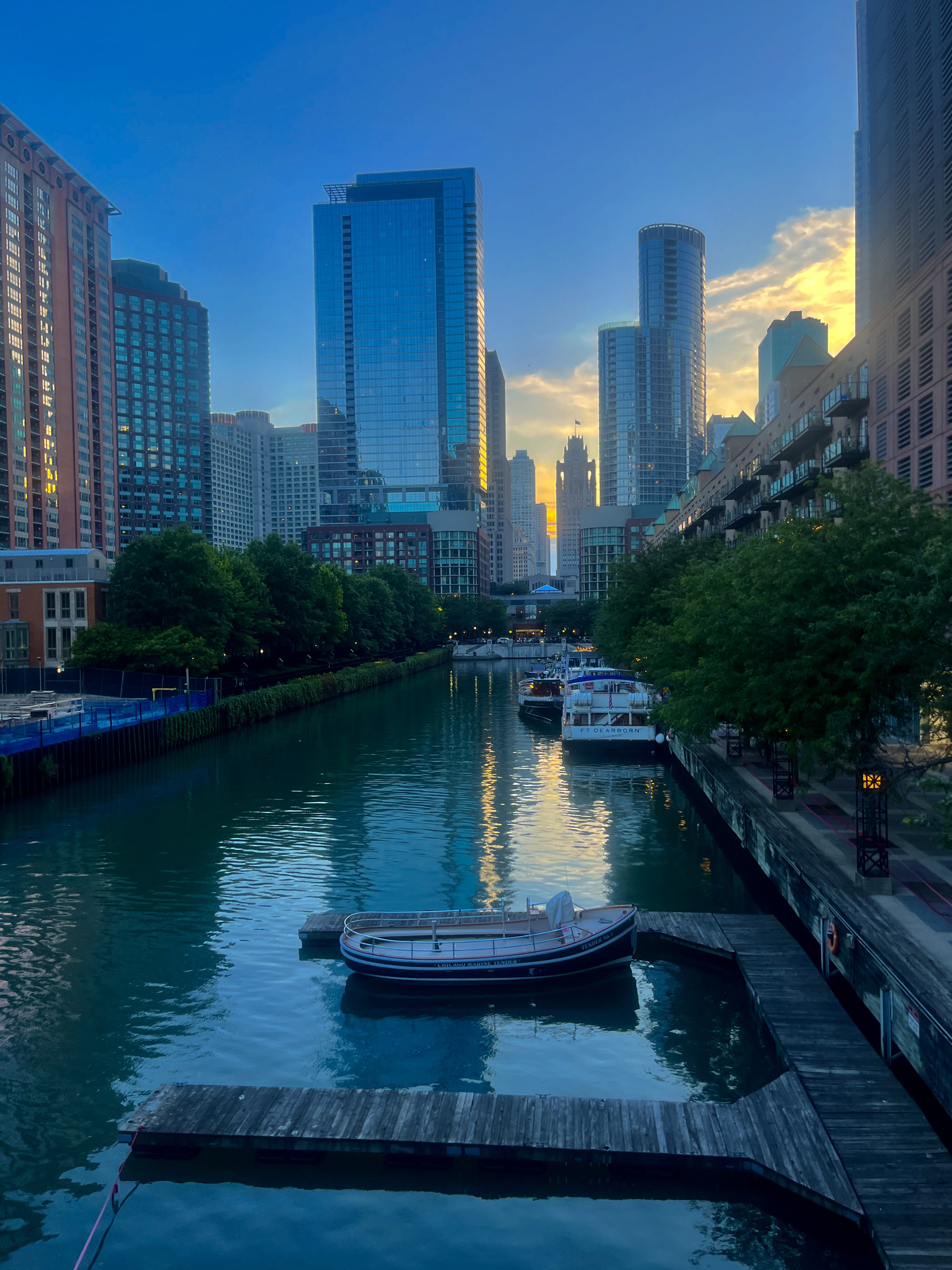 Chicago River view from a boat showing the downtown skyline with tall buildings rising from both sides of the waterway during daytime