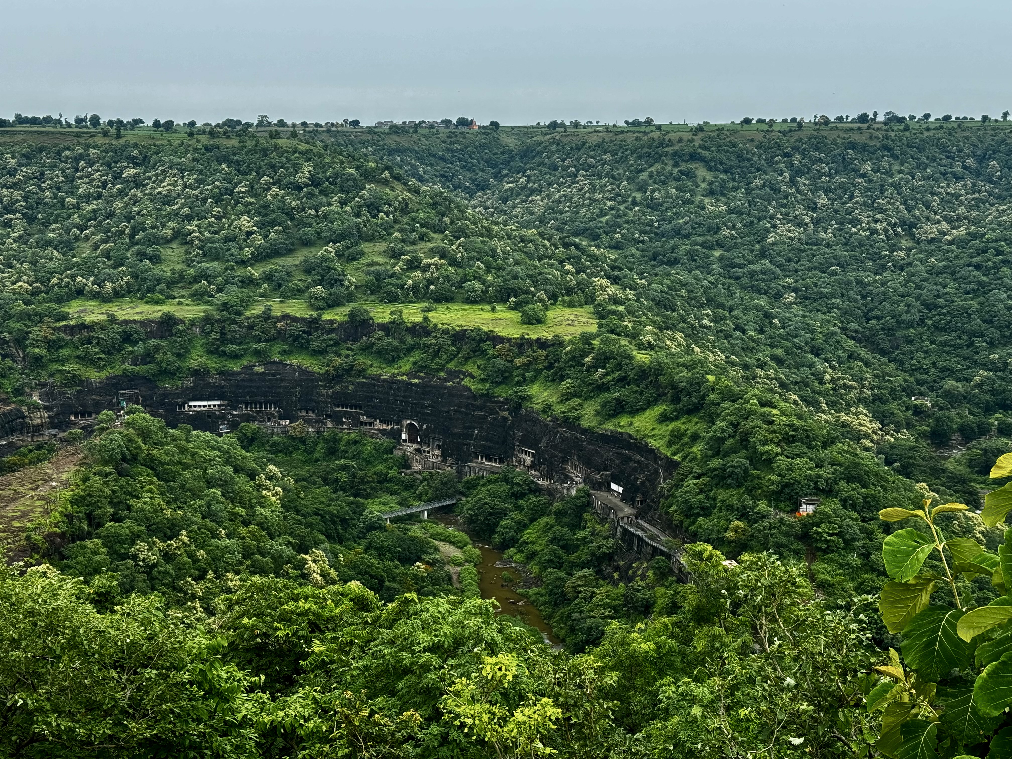 A view looking down into the valley with caves visible in the center, surrounded by hills