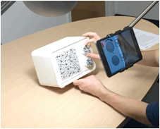 Photo of someone using the TAR representation: A physical representation of the heater is on the table and the participant is viewing the TAR representation via a mounted touchscreen while adjusting the controls on the physical representation.