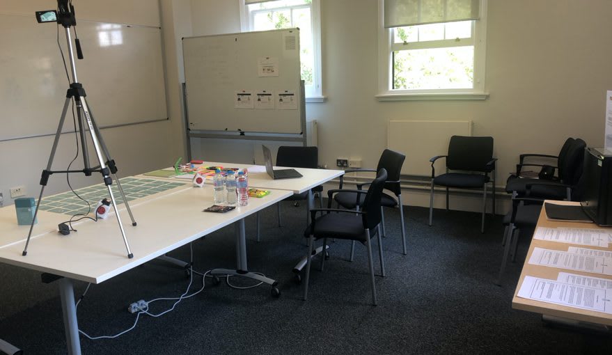 Photo of the with-cards sessions setting. The cards were spread out on the table, laptop with internet connection, whiteboard, papers, pens and sharpies, camera.