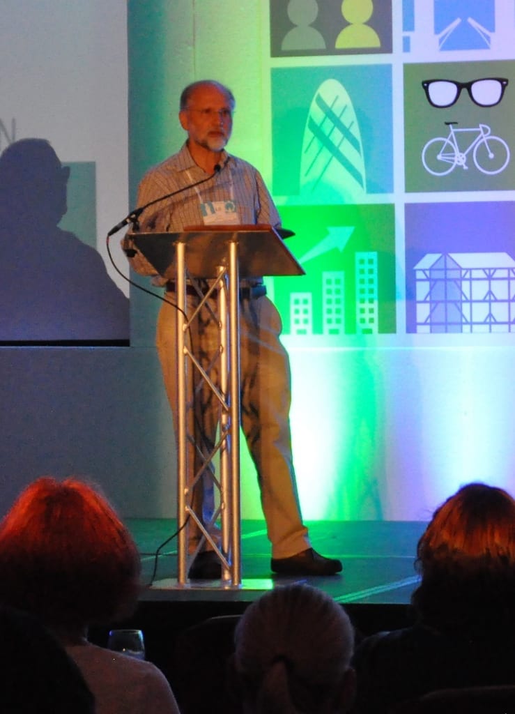 Photo of Nigel Bevan standing at a lectern and addressing the audience.