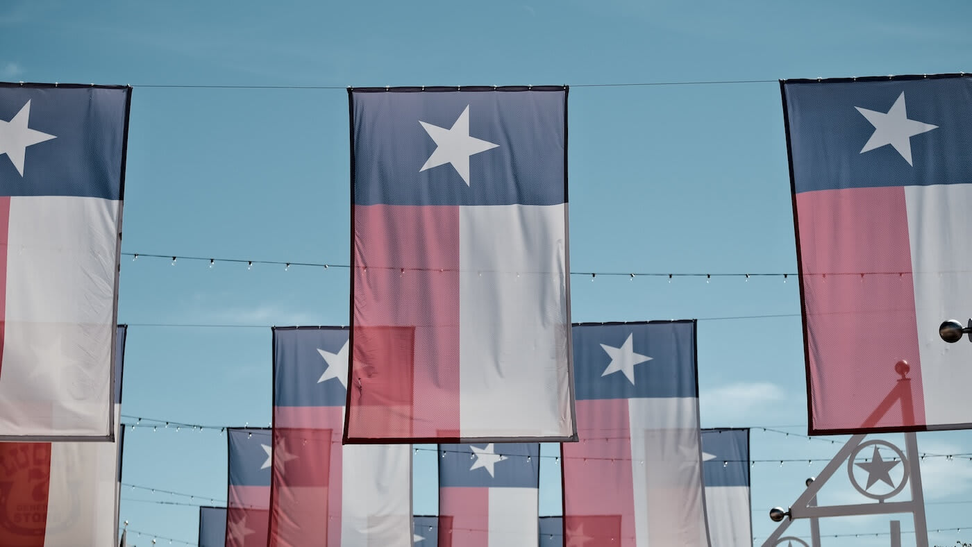Texas flags hanging in the air
