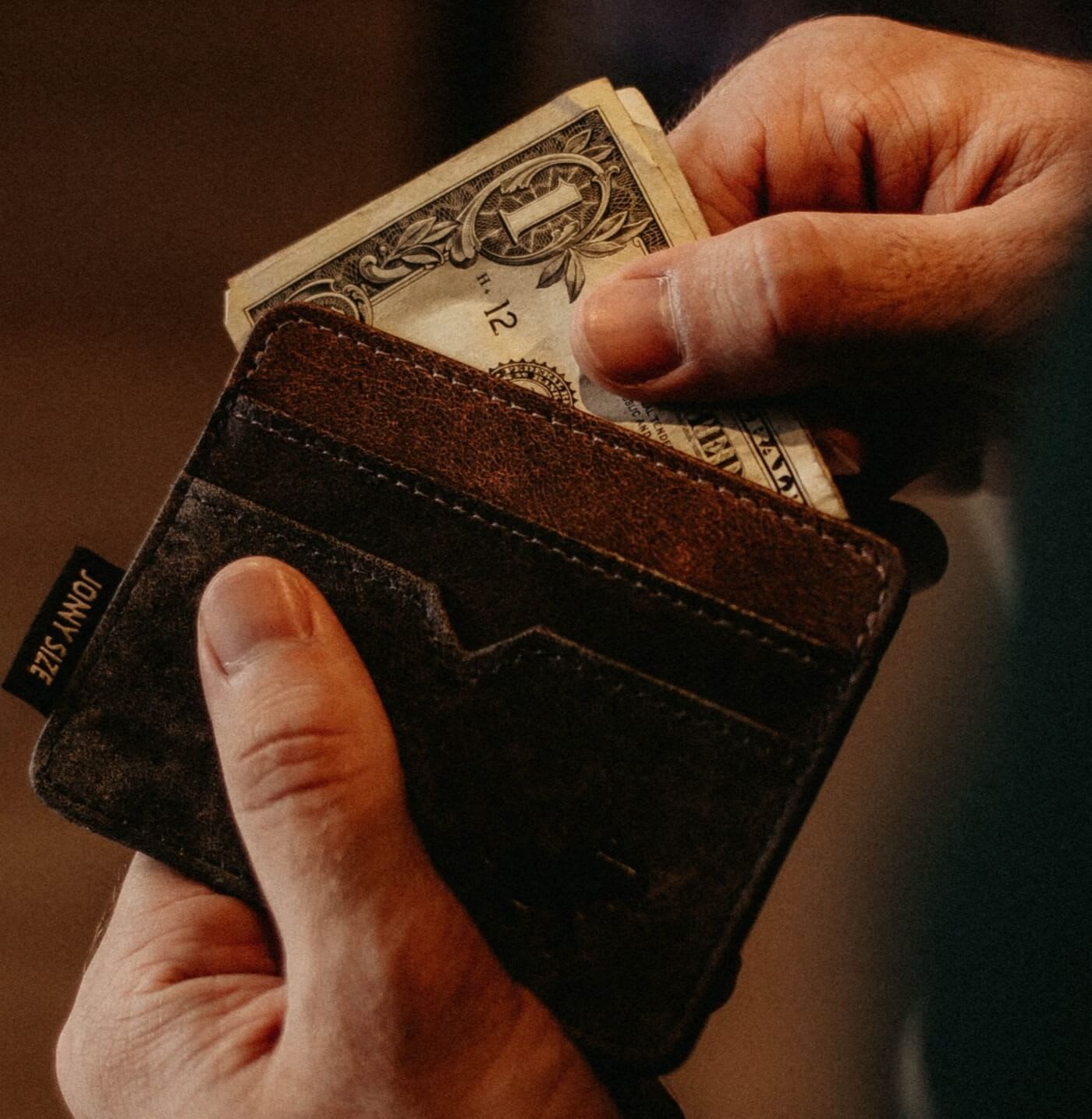 leather wallet with money being taken out