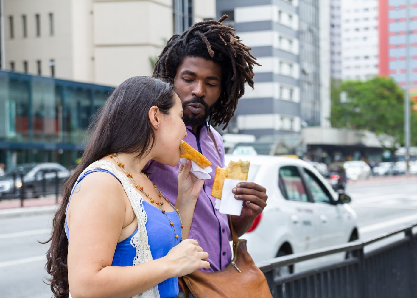 A couple eating street food while walking